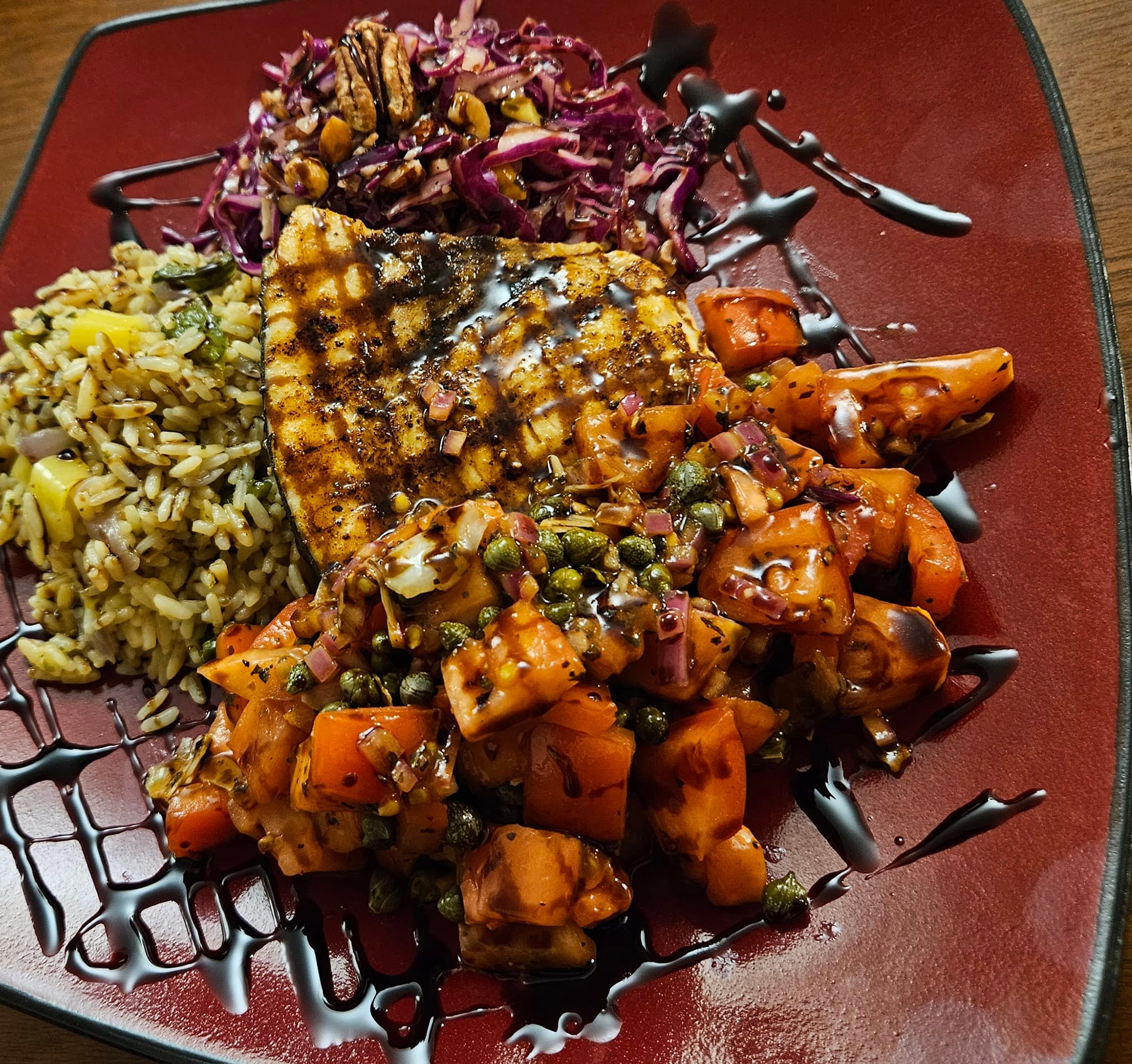 Grilled swordfish steak with warm tomato and capers topping.